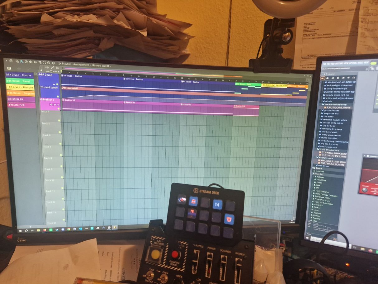 Arrangement DAW-Software auf zwei Monitoren mit Musikspuren und einem Steuergerät im Vordergrund.